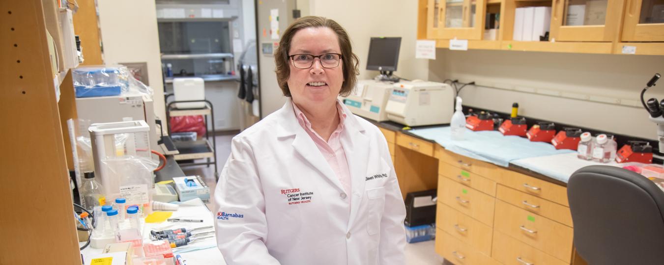 Researcher in a white lab coat at CINJ