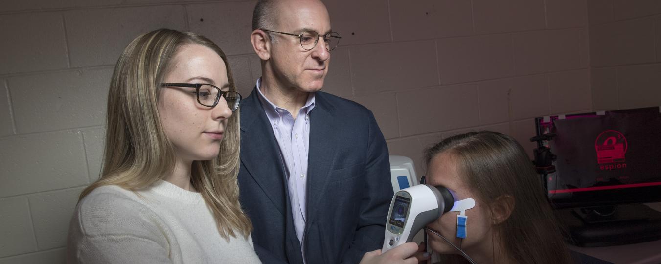 Docia Demmin (left) and Steven Silverstein demonstrate how the hand-held device RETeval may prove to be a more accessible way to diagnose schizophrenia, predict relapse and symptom severity, and assess treatment effectiveness.