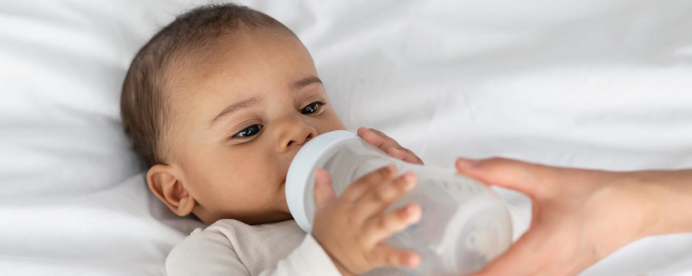 A baby drinks from a bottle