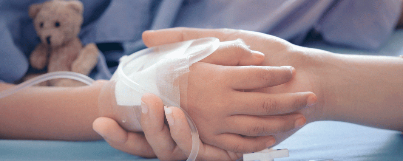 A parent holds the hand of a child in the hospital