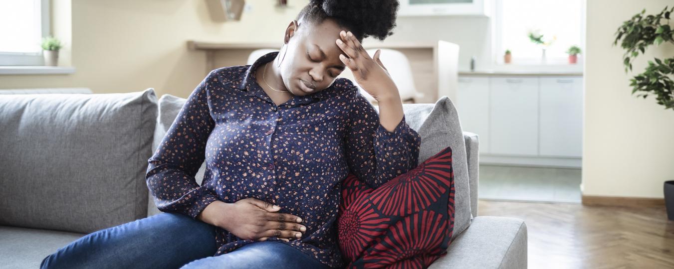 A woman holds her stomach in pain