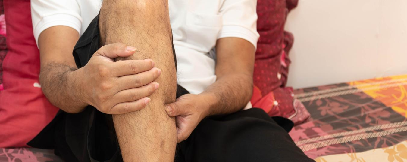 A man squeezes his calf muscle