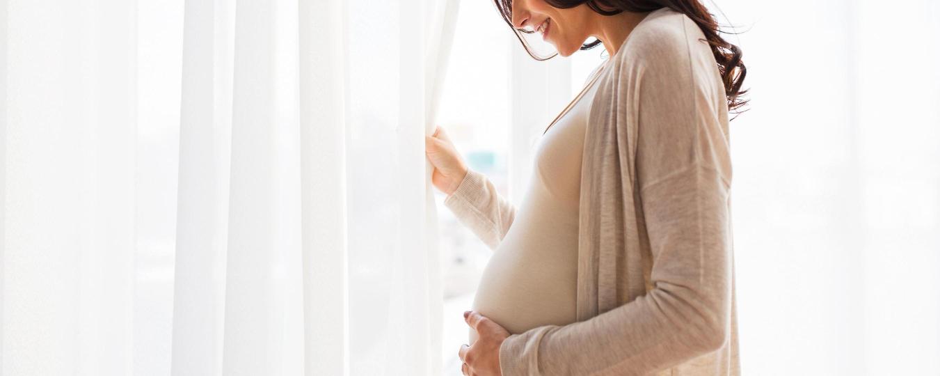 A pregnant woman cradles her bump