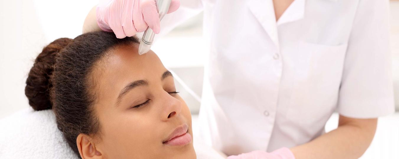 A woman receives a microneedling treatment