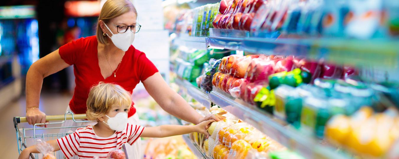 Adult and child grocery shoppin with face masks