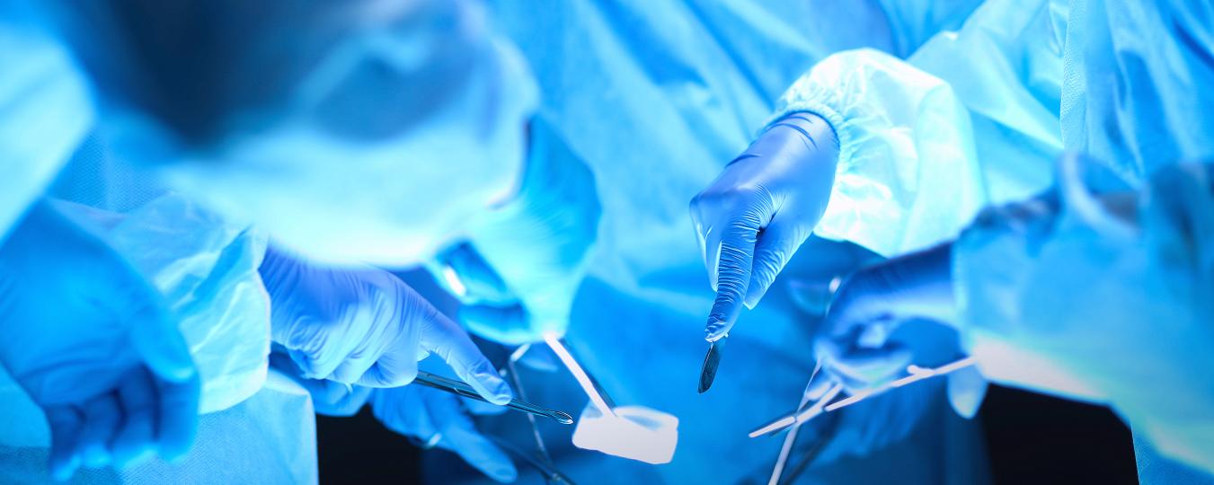 Surgeons hold instruments in an operating room