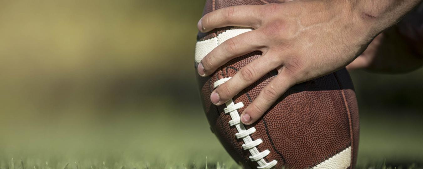 A pair of hands hold a football