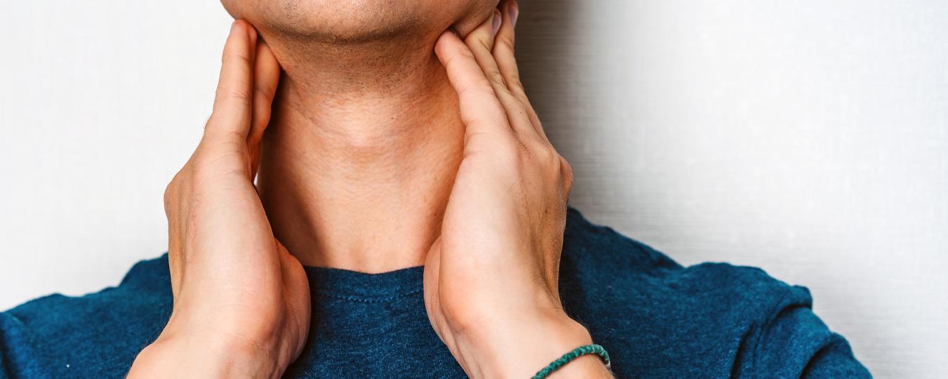 A person touching their neck