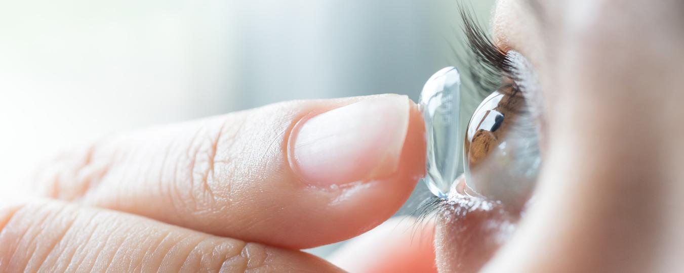 Woman applying contact lens