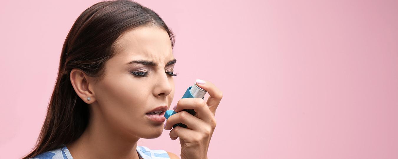 Young woman using inhaler