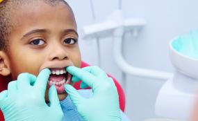 Child being checked for cavities