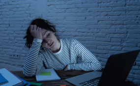 A student stresses out in front of a computer screen