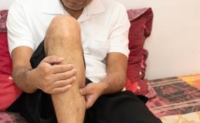A man squeezes his calf muscle