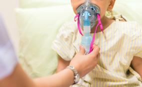 A child breathes into an oxygen mask