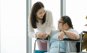 A caregiver helps a person with disabilities