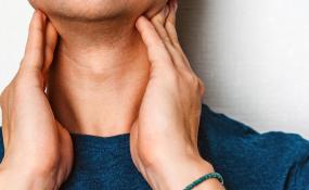 A person touching their neck